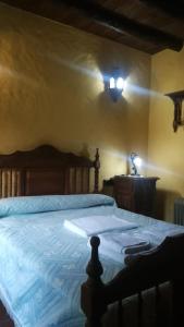 a bedroom with a bed with a light on the wall at El Cañuelo in Zahara de la Sierra