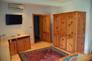 een woonkamer met houten kasten en een televisie bij Garni Hotel Berc in Bled