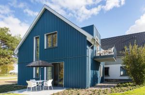 a green house with a blue facade at Haus am Deich Ferienwohnungen in Prerow