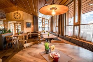 um restaurante com mesas e cadeiras de madeira e um relógio em Hotel Meiringen em Meiringen