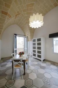 a dining room with a table and chairs and a chandelier at Charme B&B Dimora Quarta in Leverano