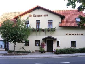 ein weißes Gebäude mit rotem Dach in der Unterkunft Hotel Pension Am Kurzentrum in Bad Suderode