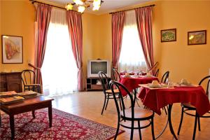 a dining room with two tables with red table cloths at Ai Tre Parchi Bed And Bike in Randazzo