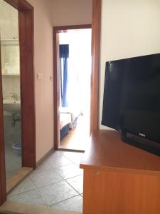 a living room with a flat screen tv and a bathroom at Apartments Savić in Neum