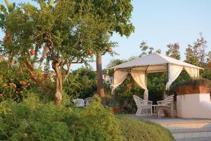 a table and chairs under an umbrella in a garden at Hotel Capizzo in Ischia