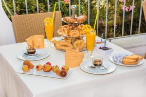 a table topped with plates of food and orange juice at Hotel Capizzo in Ischia