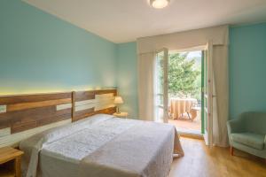 a bedroom with a bed and a chair and a window at Cà Del Moro Resort in Pontremoli