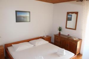 a bedroom with a white bed and a mirror at Dalia in Omiš