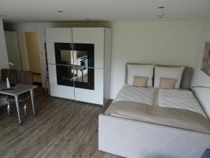 ein Schlafzimmer mit einem Bett und einem Tisch darin in der Unterkunft Ferienwohnungen am Fohrenberg in Meersburg