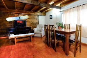 a living room with a table and a surfboard on the wall at Cabañas Don Pepe in San Carlos de Bariloche