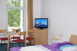 a bedroom with a bed and a tv on a wall at Residenz Seeblick in Ostseebad Sellin