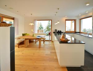 een keuken en eetkamer met een houten tafel bij Apartmenthaus Fuchsmaurer in Bressanone