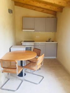 a kitchen with a wooden table and chairs at La Casa del Miele di Borgo Carbone in Locri