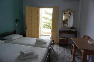 a bedroom with a bed and a table and a mirror at Country Studios in Karpathos