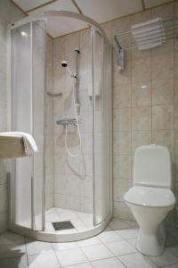 uma casa de banho com um chuveiro e um WC. em Quality Hotel Augustin em Trondheim