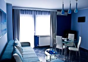 a blue living room with a couch and a table at Vila El Barco in Veliko Gradište