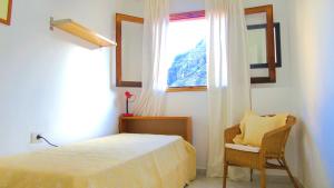 Un dormitorio con una cama y una ventana y una silla. en Apt. Lourdes, close to the Teresitas & Anaga, en San Andrés