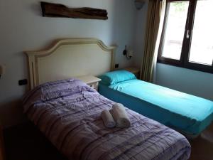 1 dormitorio con 2 camas y ventana en Villa Veronica en Sedini