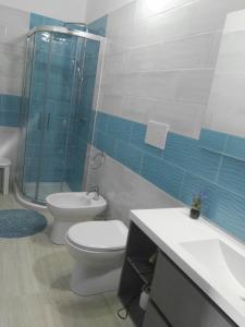 a bathroom with a toilet and a shower and a sink at B&B Casa Piras in Barùmini