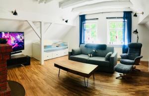 a living room with a couch and a tv at Altstadtmärchen in Leer