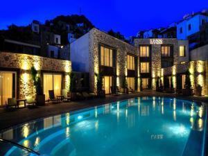 a swimming pool in front of a building at night at Lvzz Hotel in Bodrum City