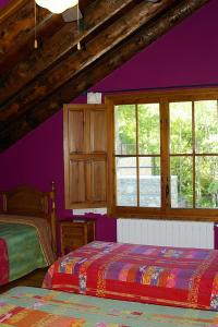 sypialnia z 2 łóżkami i fioletowymi ścianami w obiekcie Hosteleria Santa Cruz w mieście Santa Cruz de la Serós