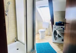 a bathroom with a washing machine and a toilet at Altstadtmärchen in Leer +12 photos