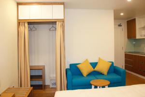 niebieska kanapa z 2 żółtymi poduszkami w pokoju w obiekcie BX Apartment w mieście Nha Trang