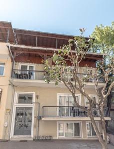 an apartment building with a balcony and a tree at Büyükada Apart Hotel - Yeni Apart in Buyukada