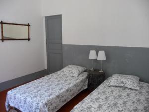 a bedroom with two beds and a lamp on a table at Casa A Rota Chambres d'Hôtes in Ersa