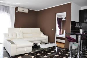 a living room with a white couch and a table at Vila El Barco in Veliko Gradište