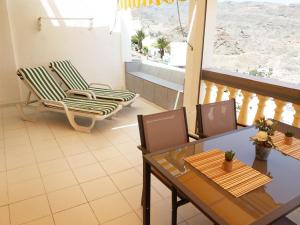 a balcony with two chairs and a table and chairs at Apartamentos Monseñor in Playa del Cura