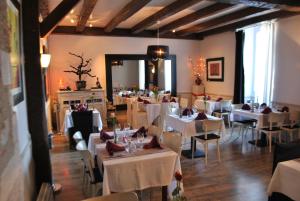 ein Esszimmer mit weißen Tischen und Stühlen in der Unterkunft Le Beffroi in Tournon-dʼAgenais