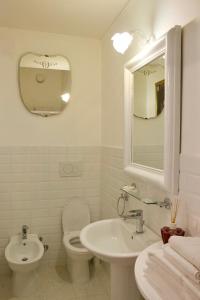 a bathroom with a toilet and a sink and a mirror at B&B Lido Liberty in Lido di Ostia +12 photos