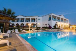 a villa with a swimming pool at night at Hotel Agia Paraskevi in Syvota