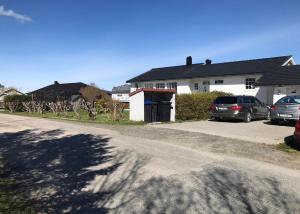 a street with cars parked in front of a house at Cozy & private room in the middle of Lofoten in Leknes