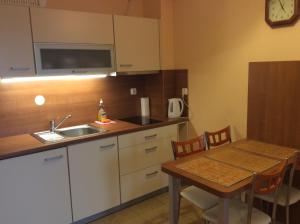 cocina con mesa, fregadero, mesa y sillas en Apartament Zdrojowa u Heleny en Świnoujście