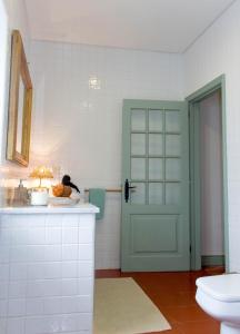 a bathroom with a green door and a sink at Casa da Igreja Velha in Furnas +45 photos