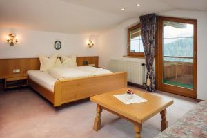 a hotel room with a bed and a coffee table at Apart Römerhof in Serfaus