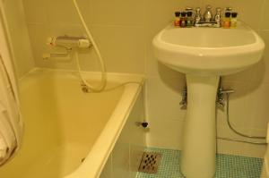 a bathroom with a sink and a toilet and a tub at Hotel Gasthof in Kagoshima