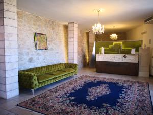 a living room with a green couch and a rug at Hotel Boutique Il Castellino Relais in Vieste