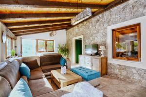 a living room with a couch and a tv at Stone House Vodice in Vodice