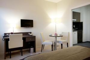 a room with a desk and a table and chairs at Residhome Reims Centre in Reims