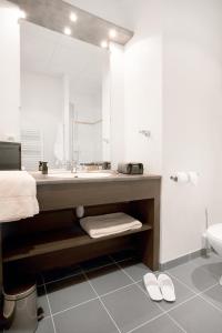 een badkamer met een grote wastafel en een toilet bij Residhome Reims Centre in Reims