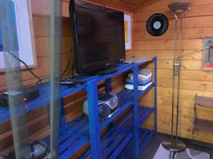 a television on a blue stand in a room at Páros faház in Balatonföldvár