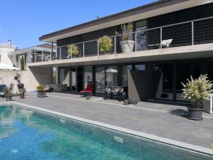 a house with a swimming pool in front of it at Morat Gaste Zimmer in Murten