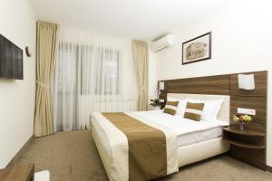 a hotel room with a large bed and a window at Grand Hotel Coroana in Bistriţa