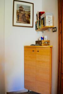 um armário de madeira com livros ao lado de uma parede em Jimmy's Place em Órmos Marathokámpou