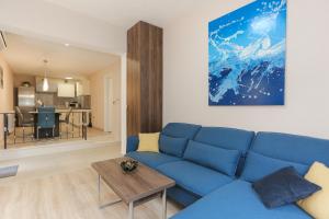 Una sala de estar con un sofá azul y una mesa. en Keko, en Supetar