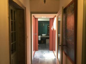 a hallway leading to a bathroom with pink doors at Casa da Igreja Velha in Furnas +54 photos